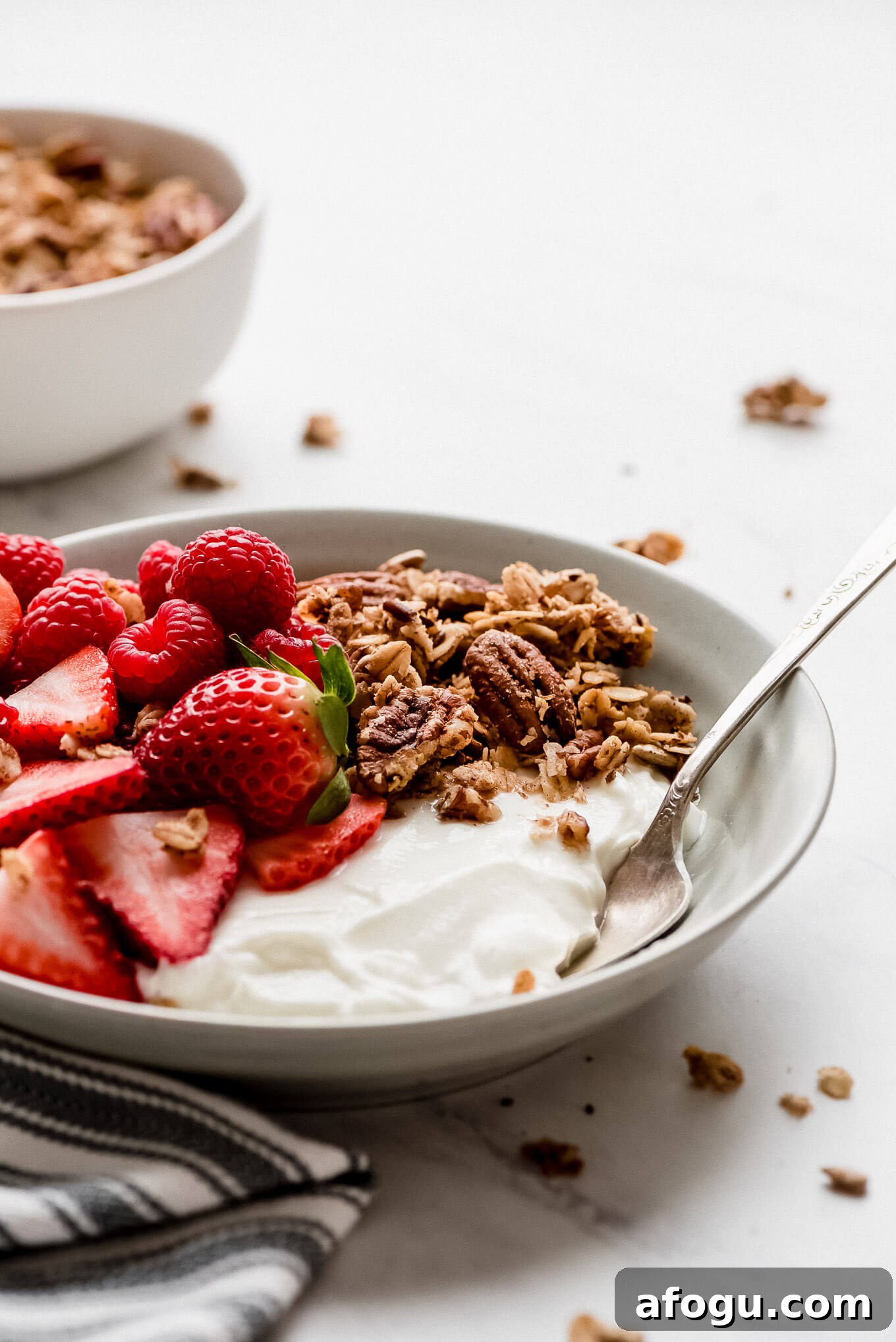 Greek yogurt bowl with strawberries, raspberries, and granola. A bowl of Greek yogurt topped with strawberries, raspberries, and granola.