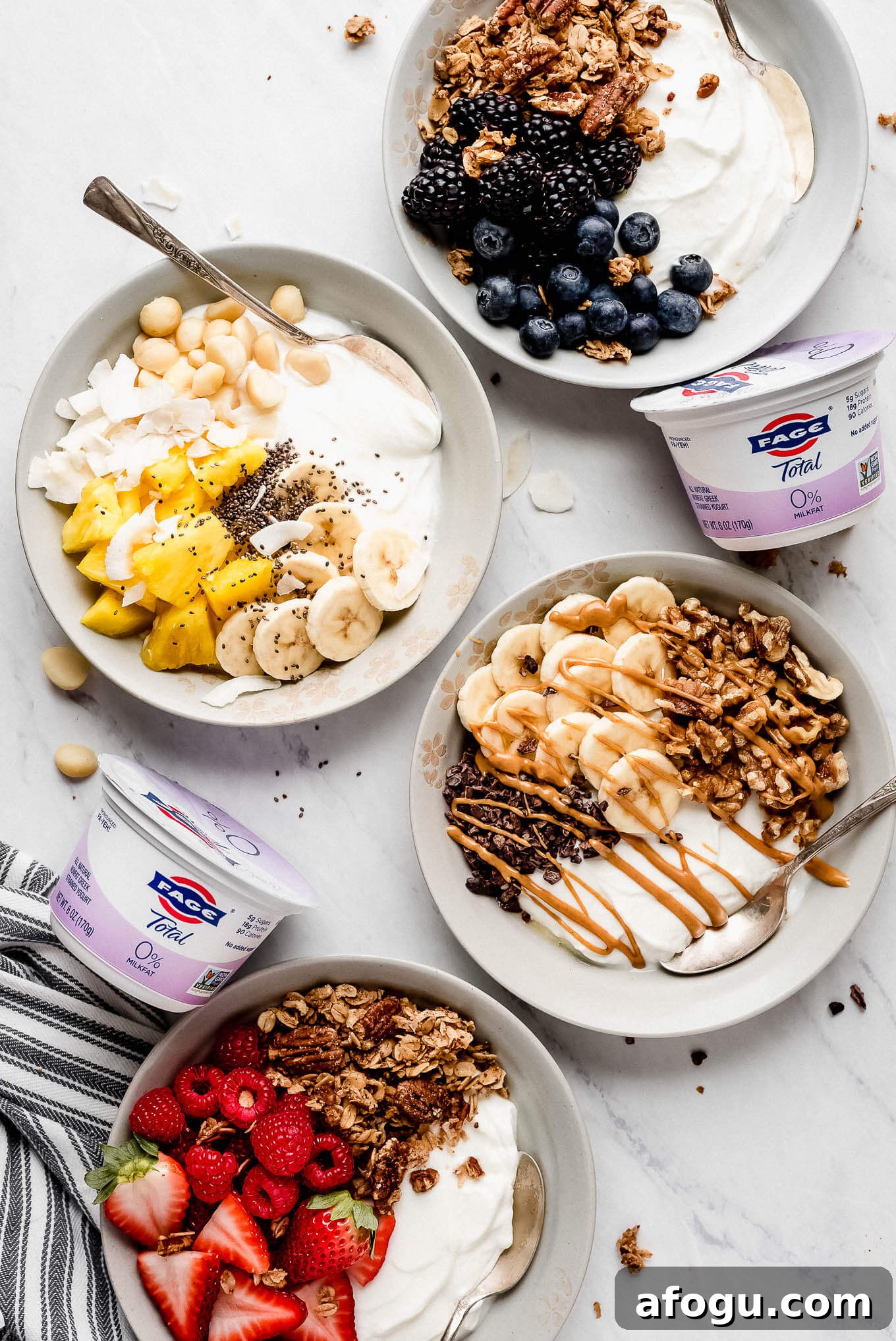 Four Greek yogurt bowls. Blueberry yogurt bowl, Tropical yogurt bowl, chunky monkey yogurt bowl, and red berry yogurt bowl.