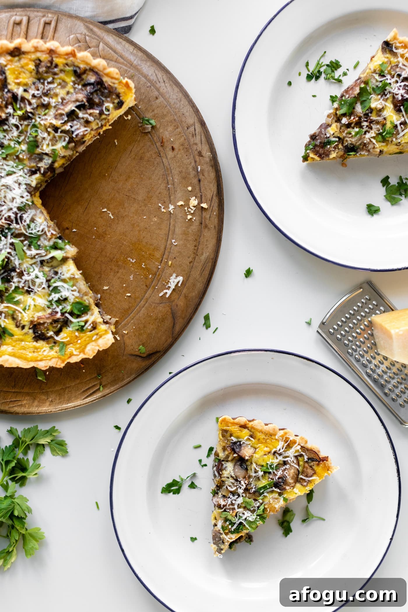 Breakfast quiche topped with parsley and Parmesan cheese with pieces cut out on bread board with extra cheese and parsley all sitting on white surface