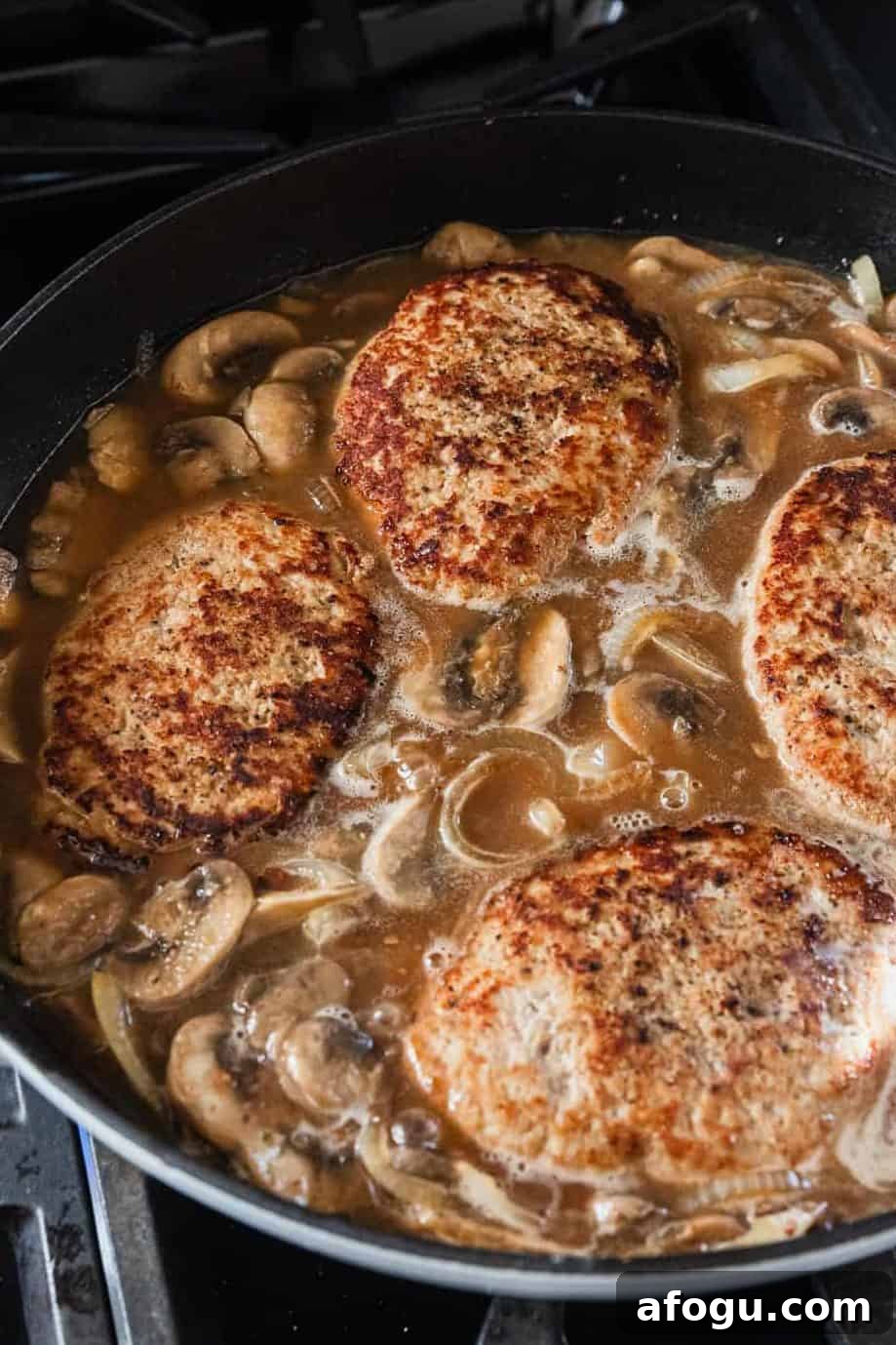 Simmering turkey patties in the gravy.