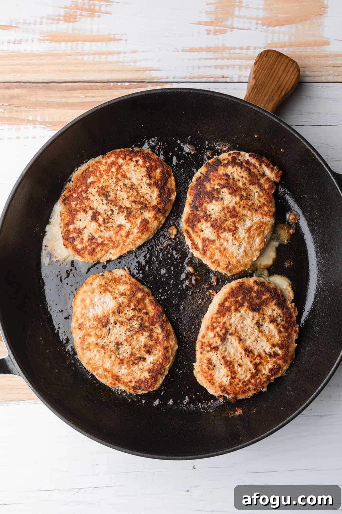 Cooked tukey patties in the skillet.