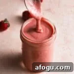 strawberry curd in a jar with a spoon.
