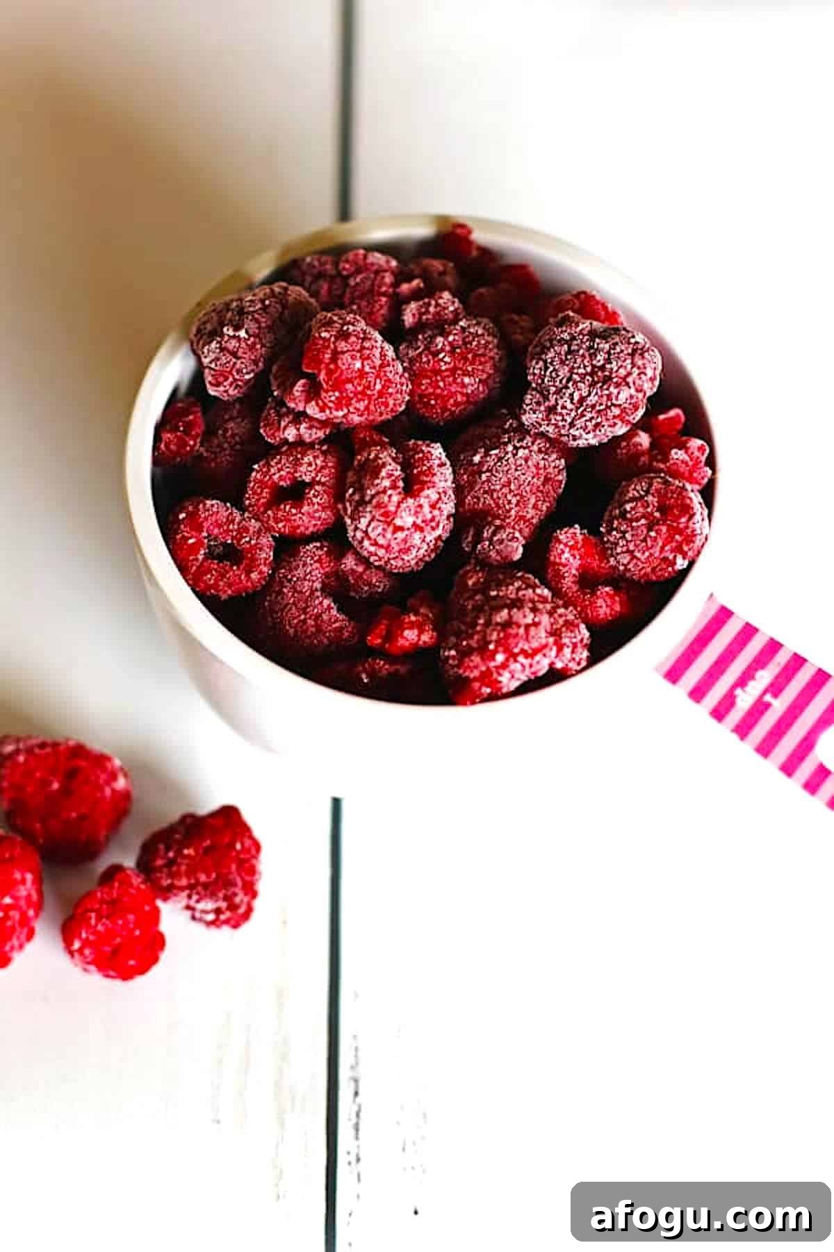 Frozen raspberries in a measuring cup