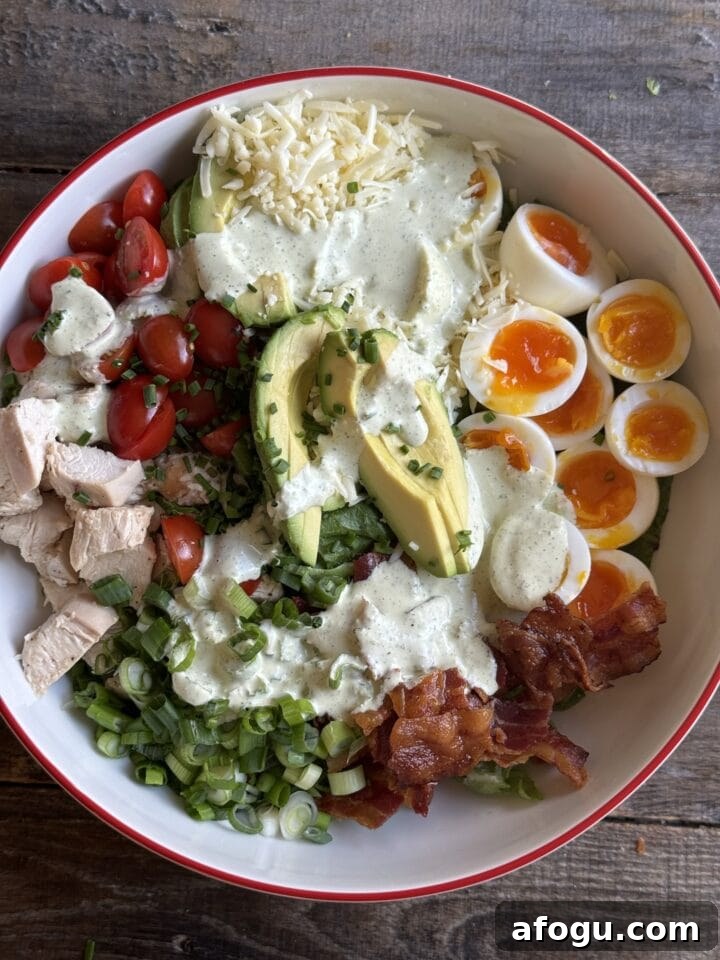 Creamy Chicken Cobb Salad Recipe with Avocado & Bacon 10 a photo of dressing drizzled on top of the chicken cobb salad