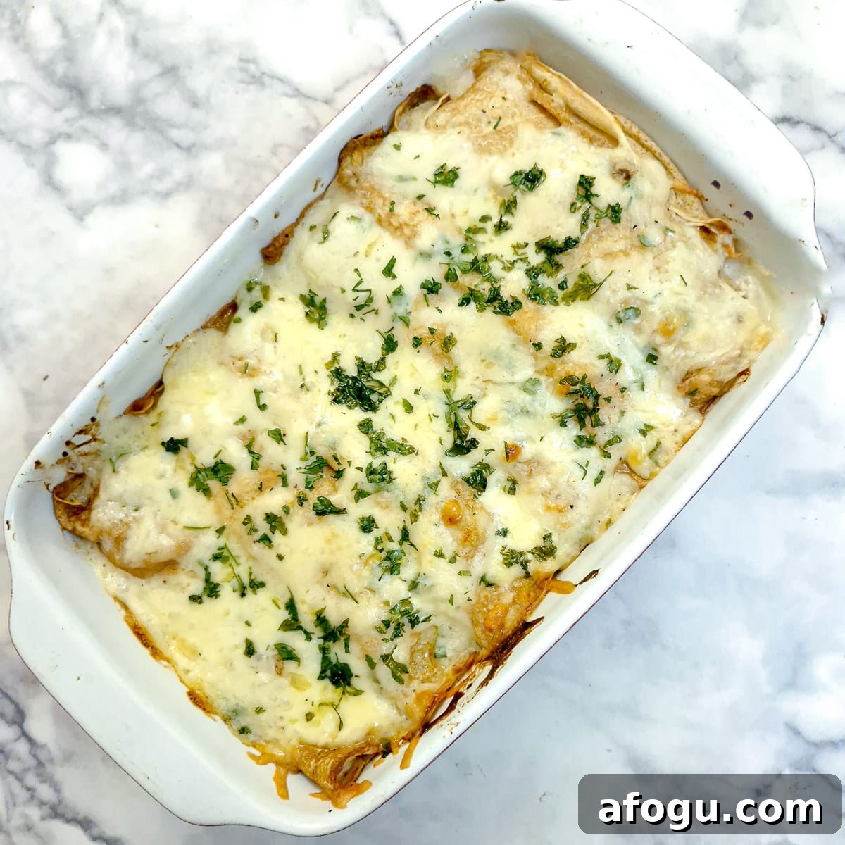 A fully baked dish of seafood stuffed pancakes covered in melted cheese.