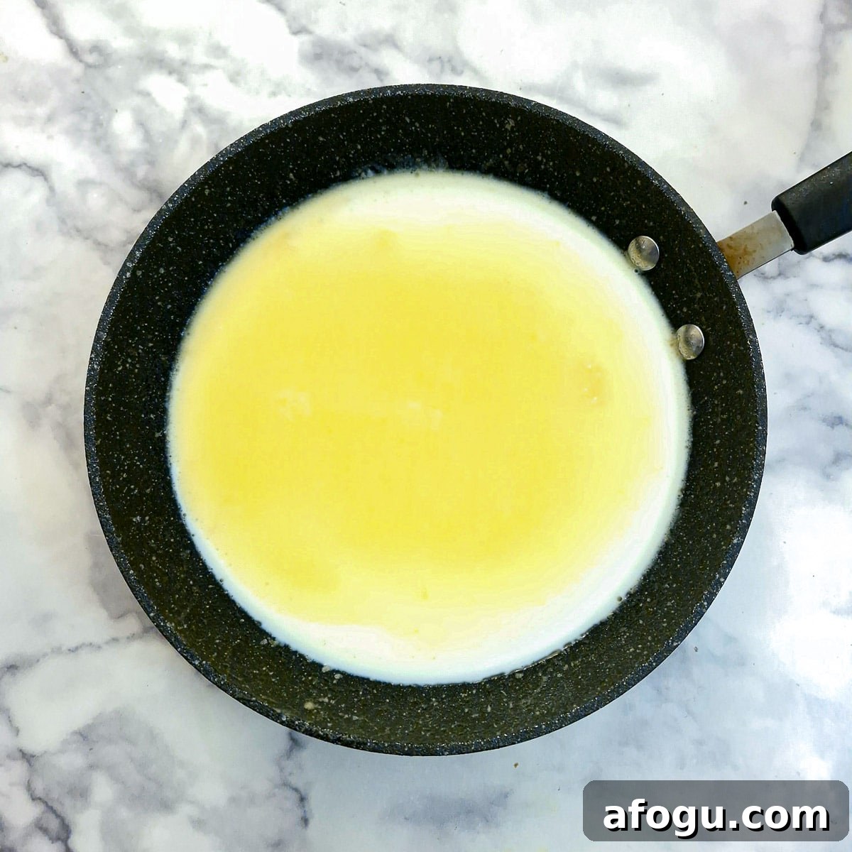 Bechamel sauce being thickened in a frying pan.