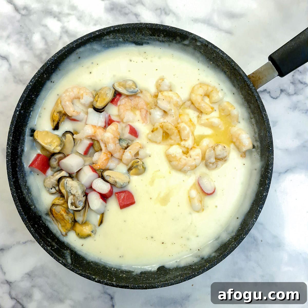 Mixed seafood being added to the sauce.