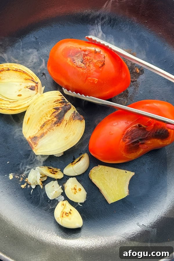 tomatoes, onion and garlic roasting in a pan for salsa