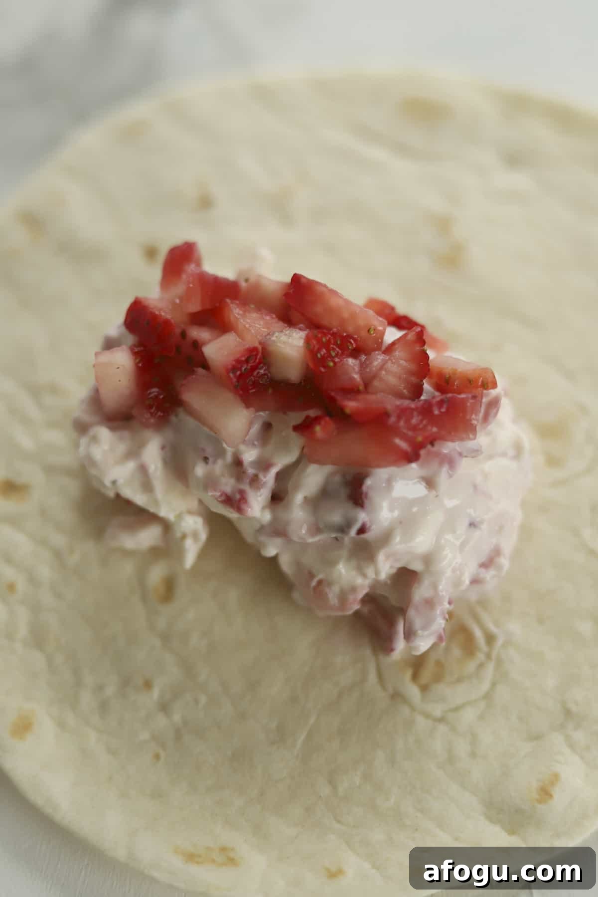 a tortilla shell with a strawberry cream cheese mixture in the center