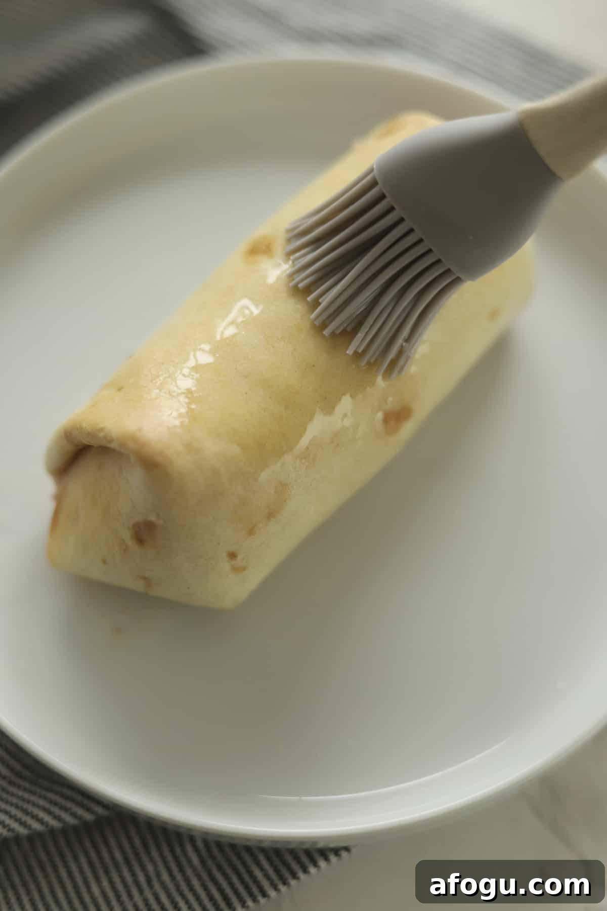 chimichanga being brushed with butter