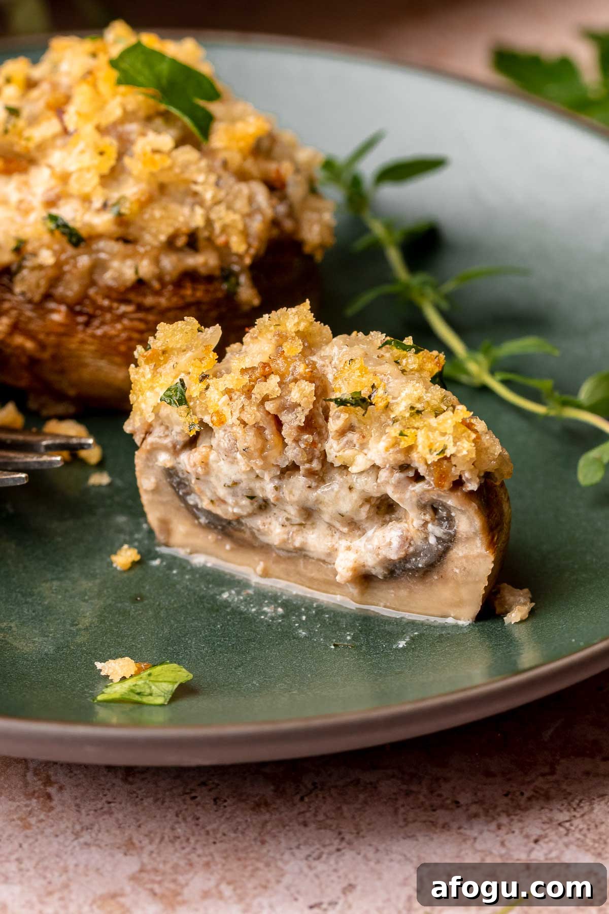 A boursin stuffed mushroom cut open on a plate.