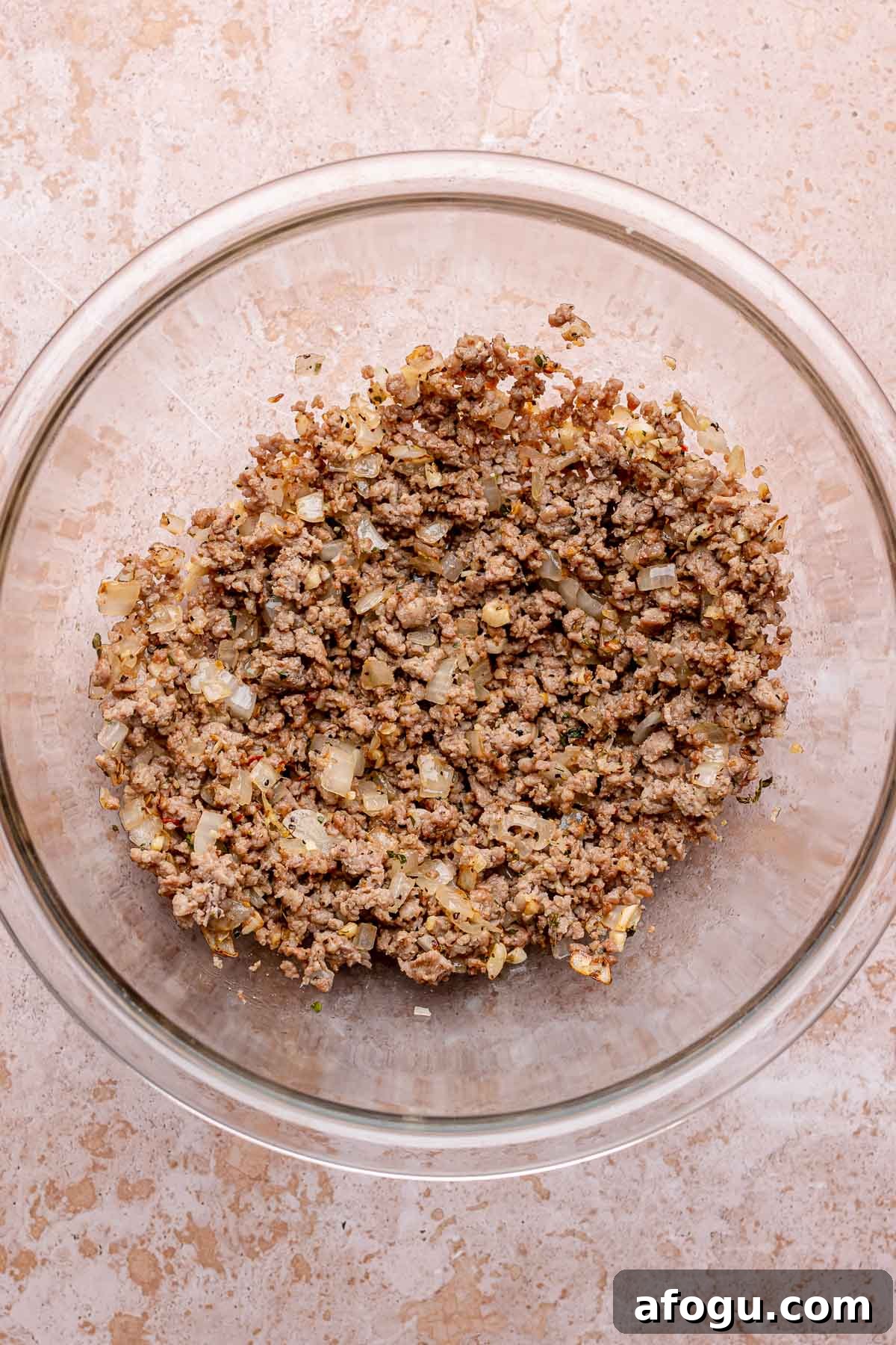 Cooked ground sausage and onions in a large mixing bowl.