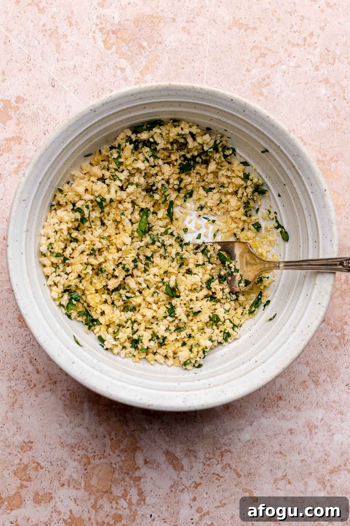 Panko breadcrumbs and parsley in a bowl with a fork.
