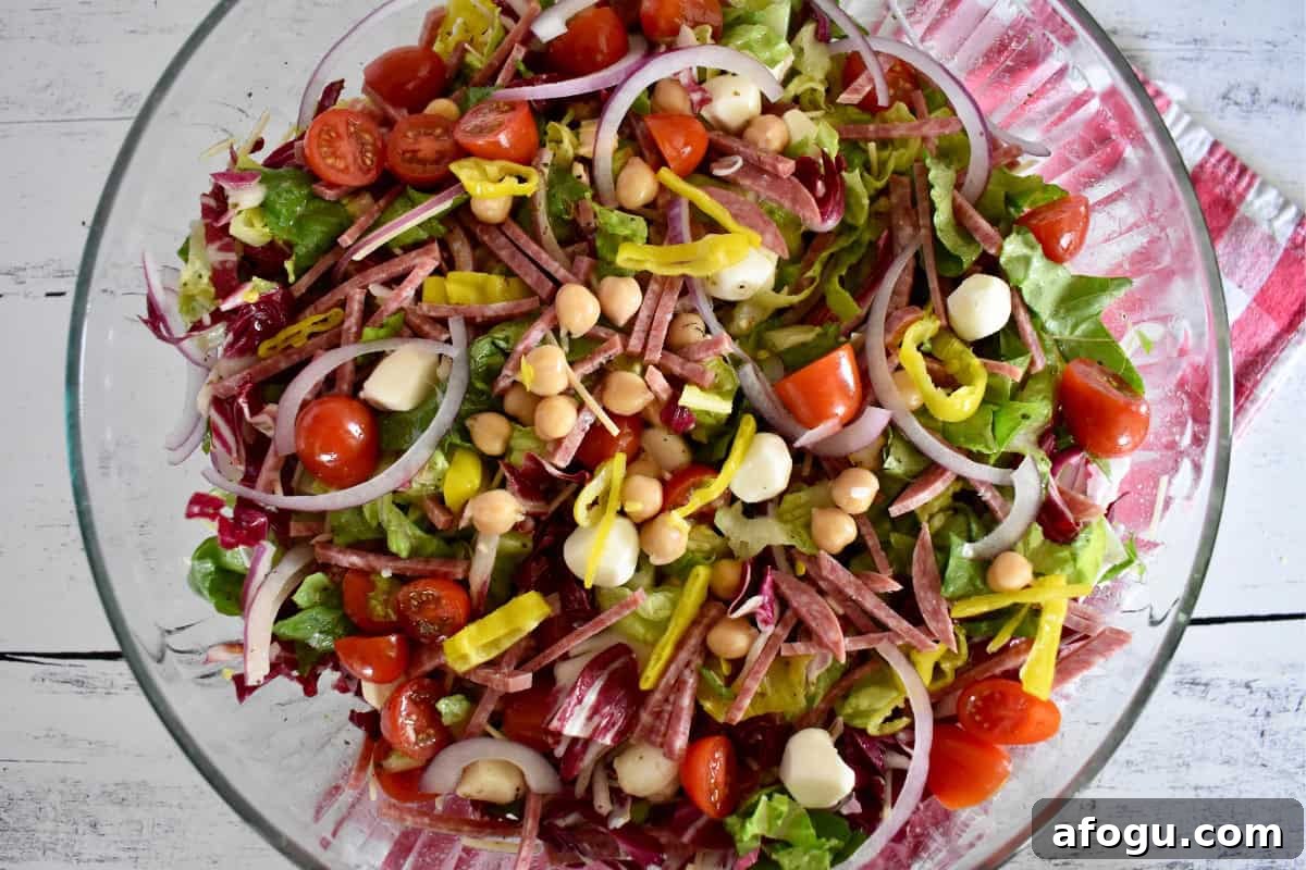 Italian Chopped Salad in a glass bowl with a checkered napkin underneath. 