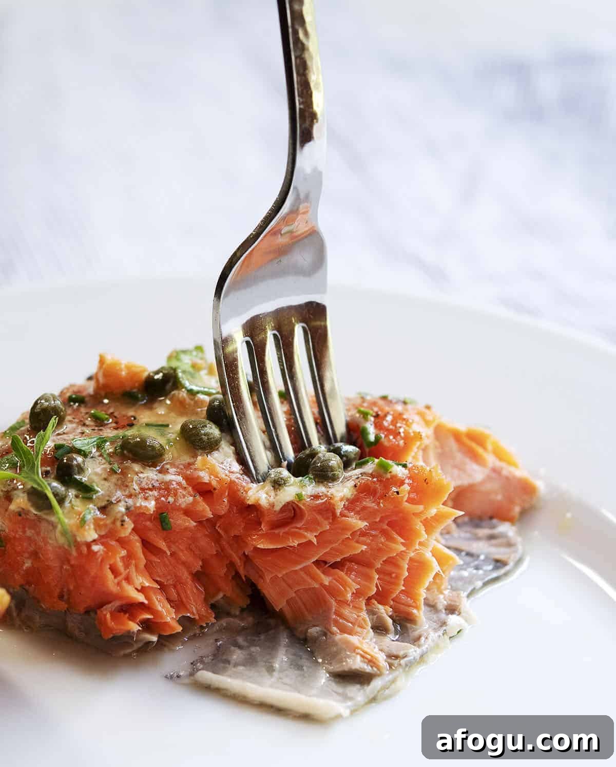 Taking a bite of slow roasted salmon