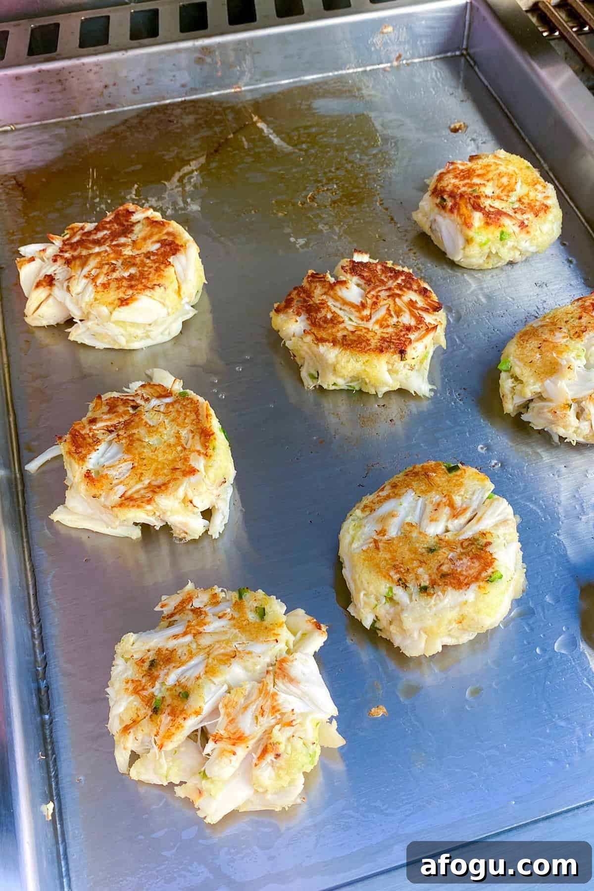 crab cakes on griddle seared.
