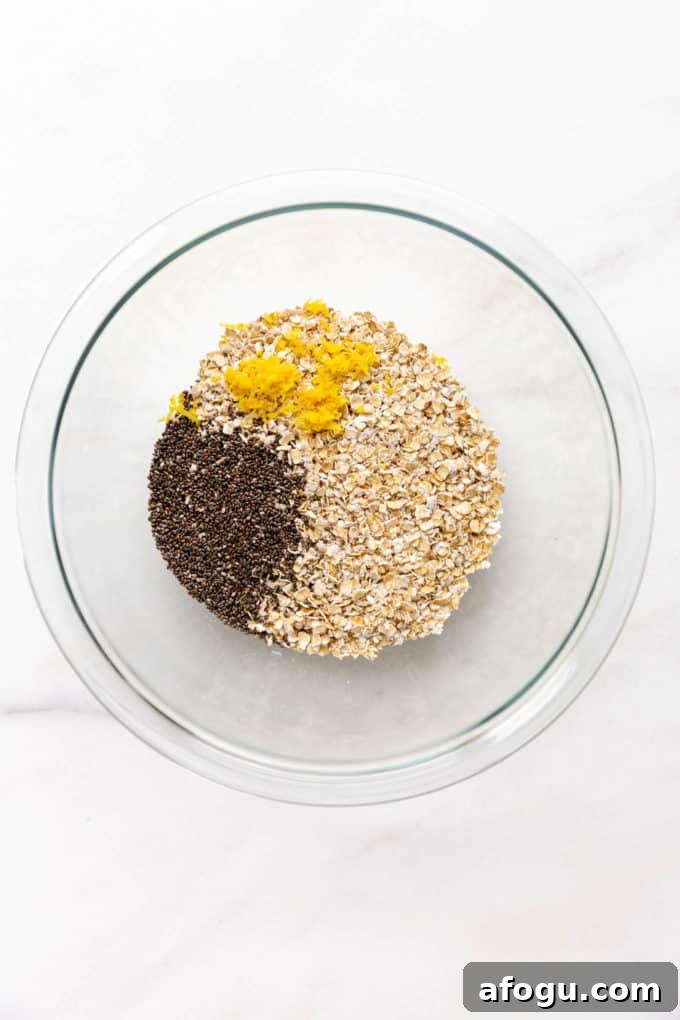 A clear mixing bowl with oats, chia seeds and lemon zest