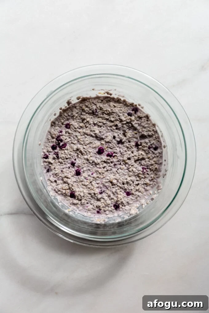 blueberry overnight oats in a clear mixing bowl.
