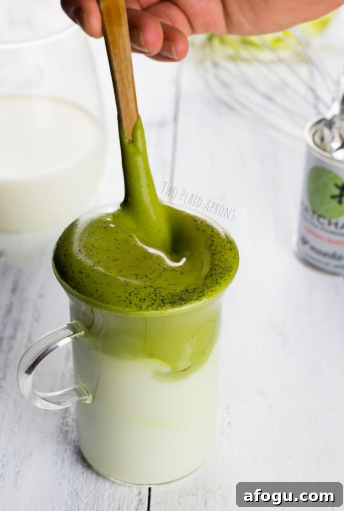 Dalgona Matcha Latte Recipe: Whipped Green Tea Coffeehouse Drink 4 Stirring our glass of dalgona matcha latte.