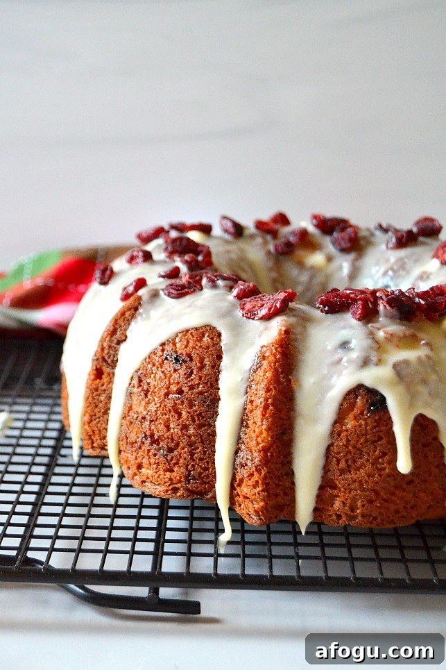 White chocolate cranberry bundt cake on a black wire rack
