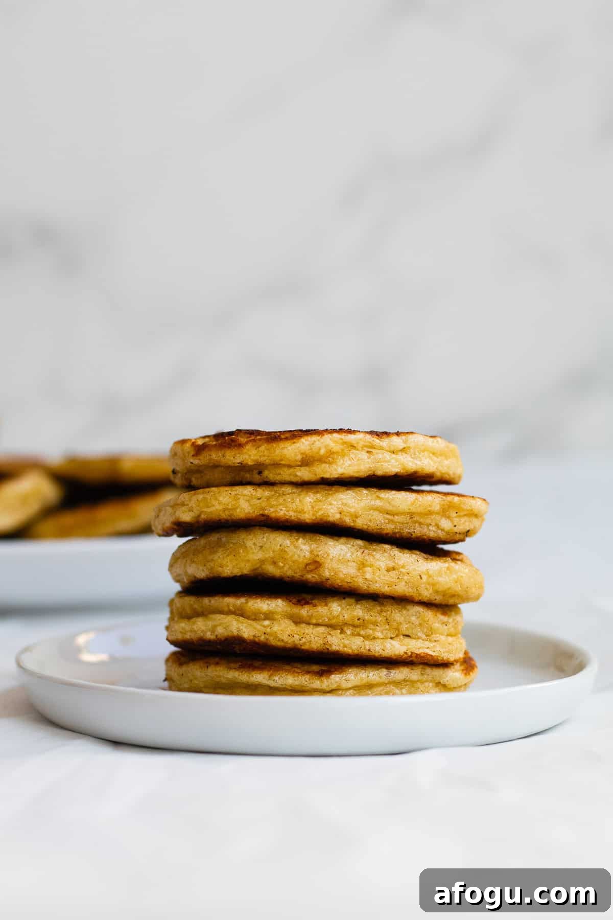 6-Ingredient Cottage Cheese Oatmeal Pancakes Recipe 8 stack of pancakes on white plate