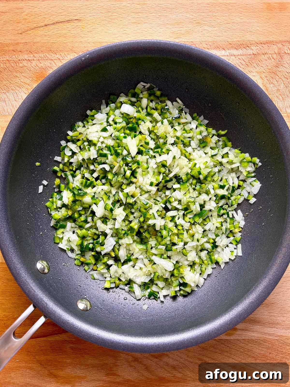 sautéing onions and chilis in pan