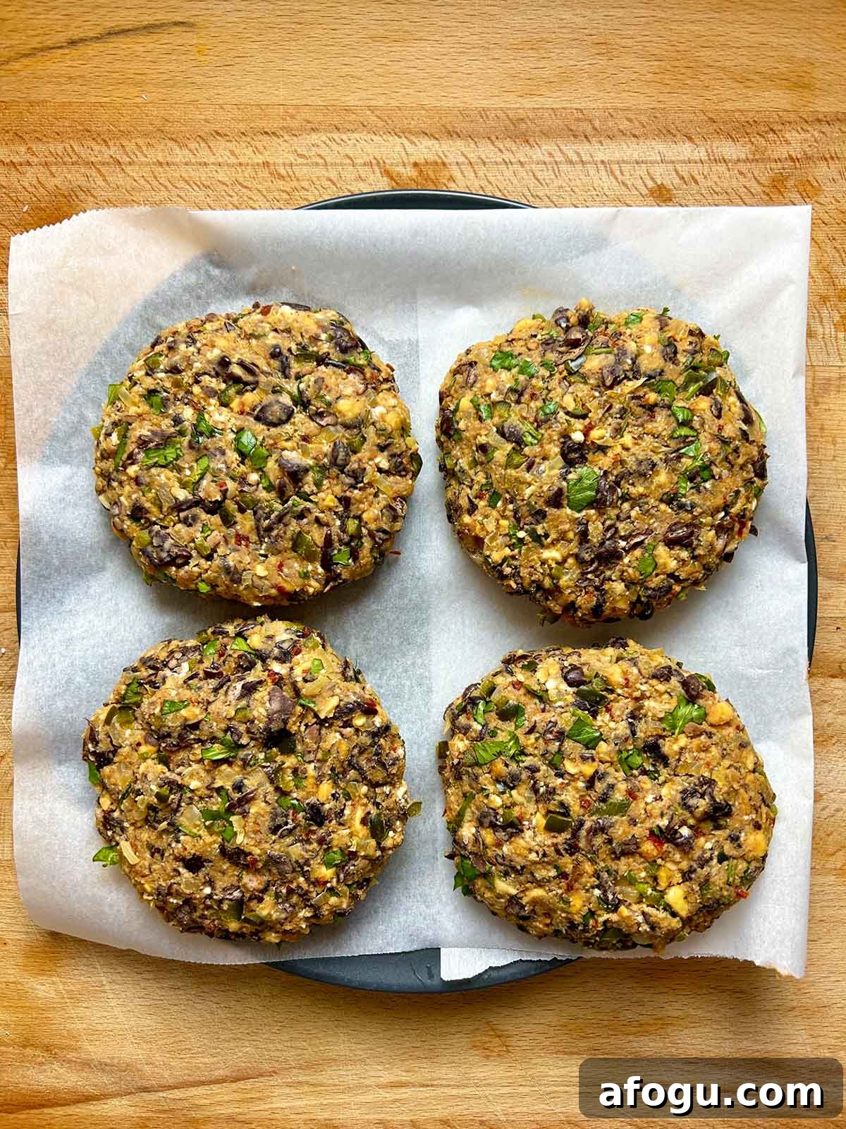 four shaped black bean patties on plate