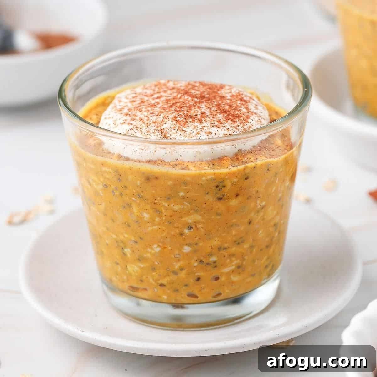 Glass jar of overnight oats topped with yoghurt and pumpkin spice.
