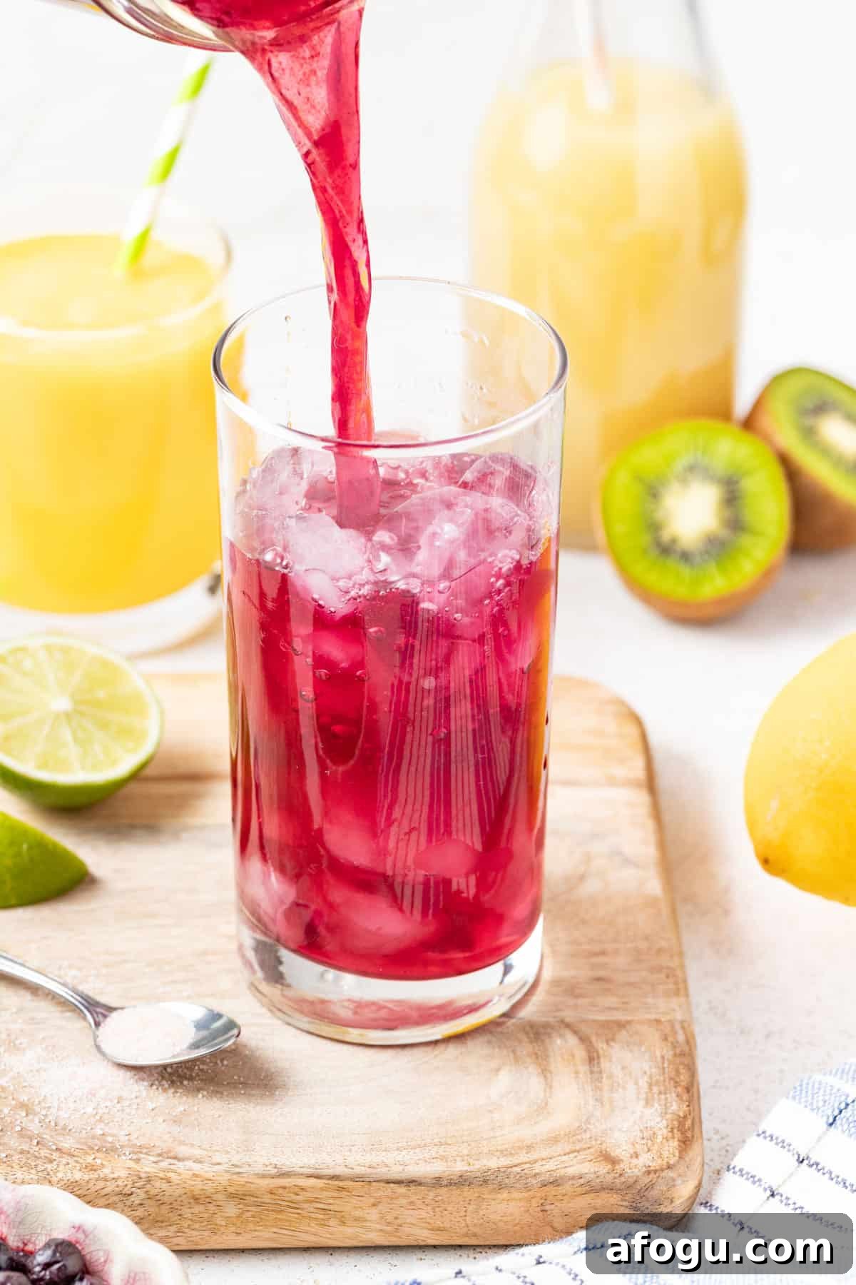Pouring the berry electrolyte mixture into a glass with ice.