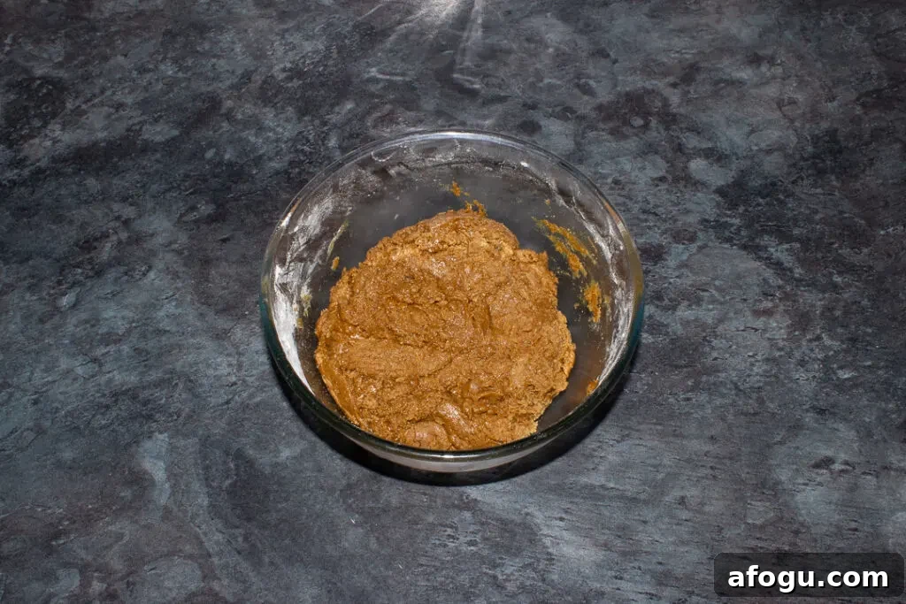 Classic Gingerbread Biscuit Recipe for Perfect Holiday Baking 12 Gingerbread biscuit dough in a large bowl on a kitchen worktop.