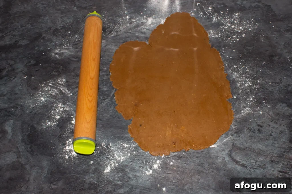 Classic Gingerbread Biscuit Recipe for Perfect Holiday Baking 14 Gingerbread biscuit dough rolled out on a floured kitchen worktop with a rolling pin at the side.
