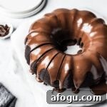 Close up of sliced bundt cake on a white marble background