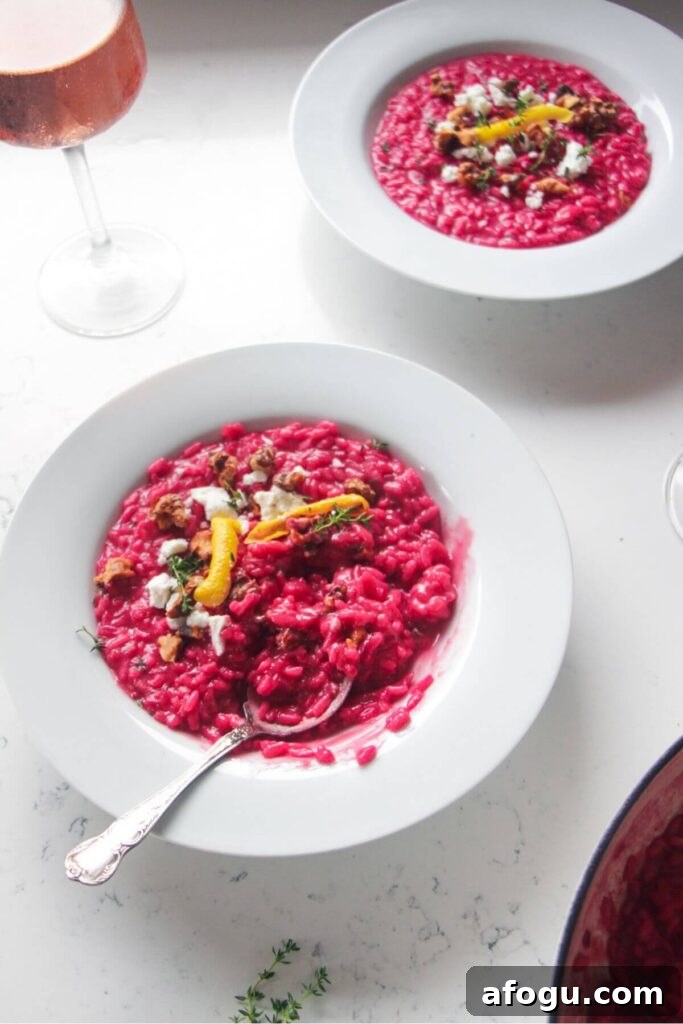 Bright pink beetroot risotto in a white bowl.