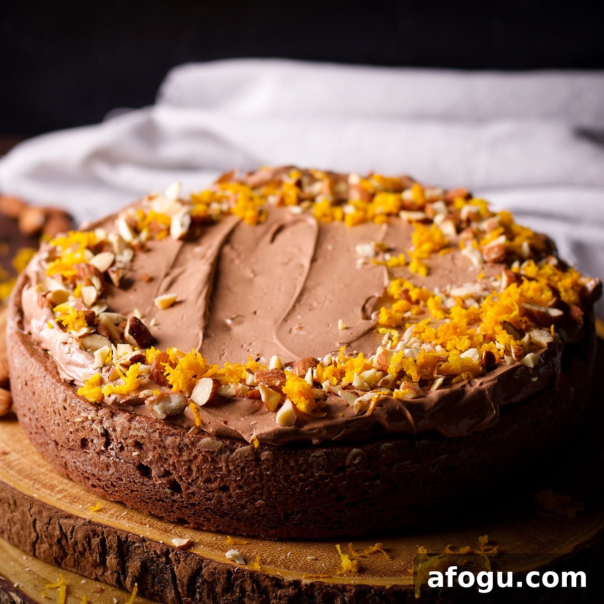 A one layer chocolate almond cake that's been frosted with chocolate orange buttercream and decorated with chopped almonds and orange zest.