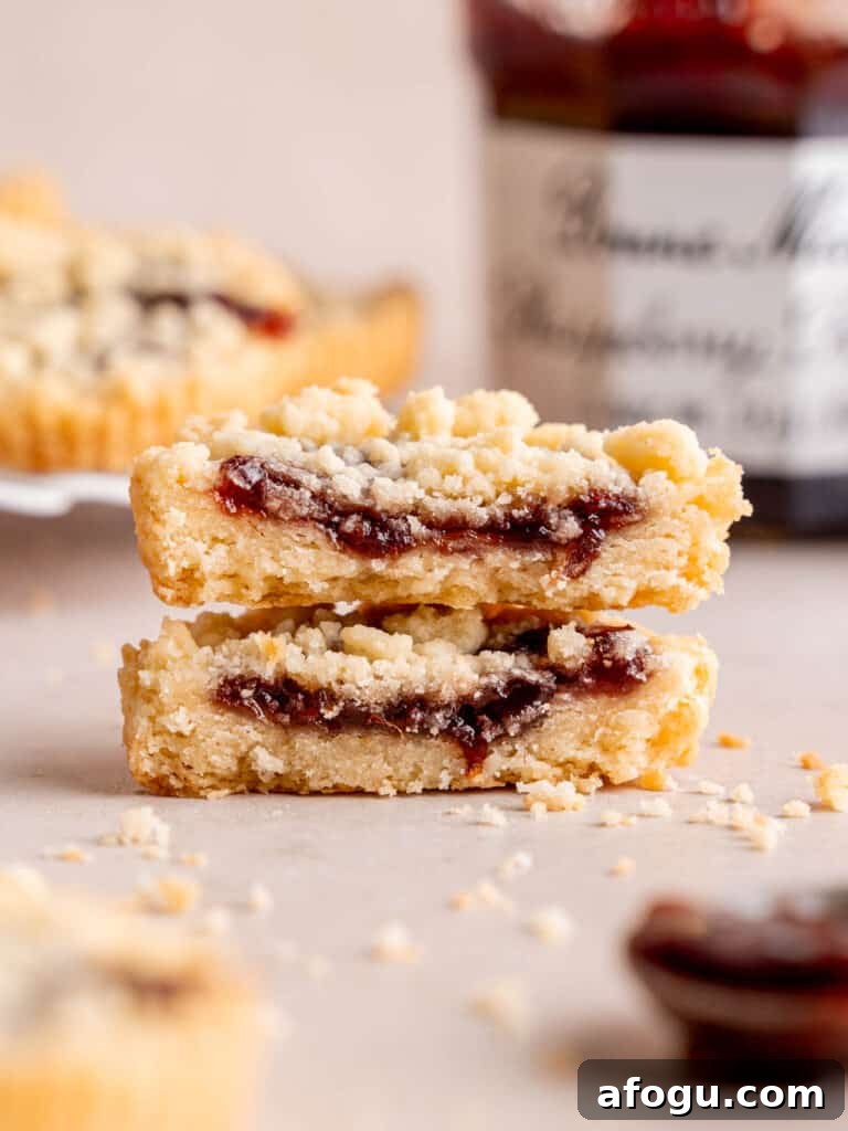 Two halves of a raspberry crumble cookie stacked on top of each other.