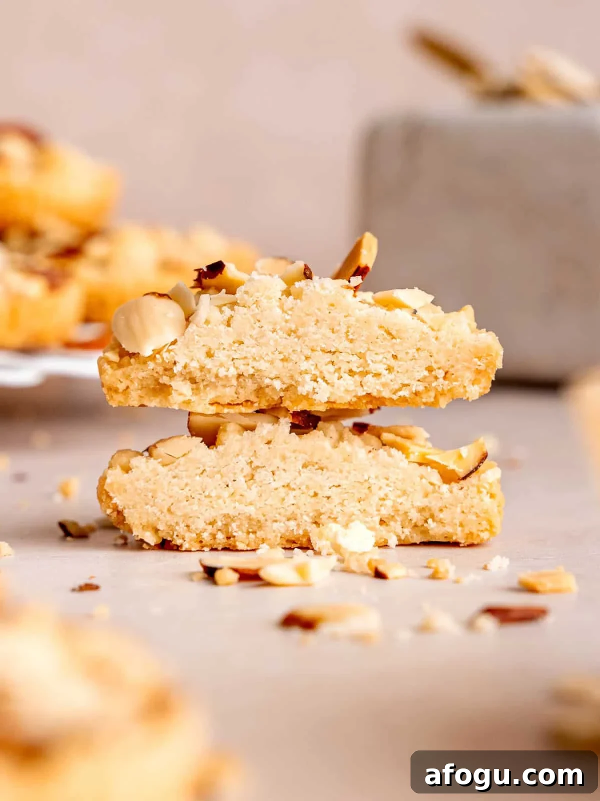 A stack of shortbread cookies cut in half showing their almond filling.