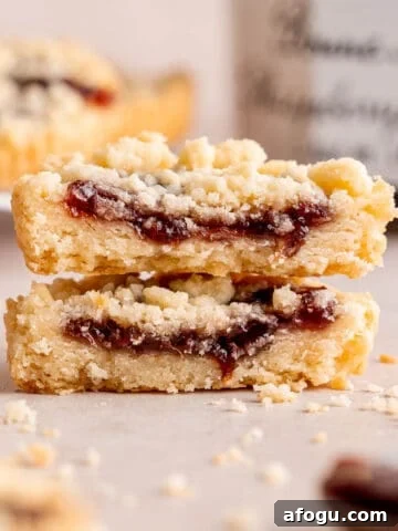 Two halves of a raspberry crumble cookie stacked on top of each other.