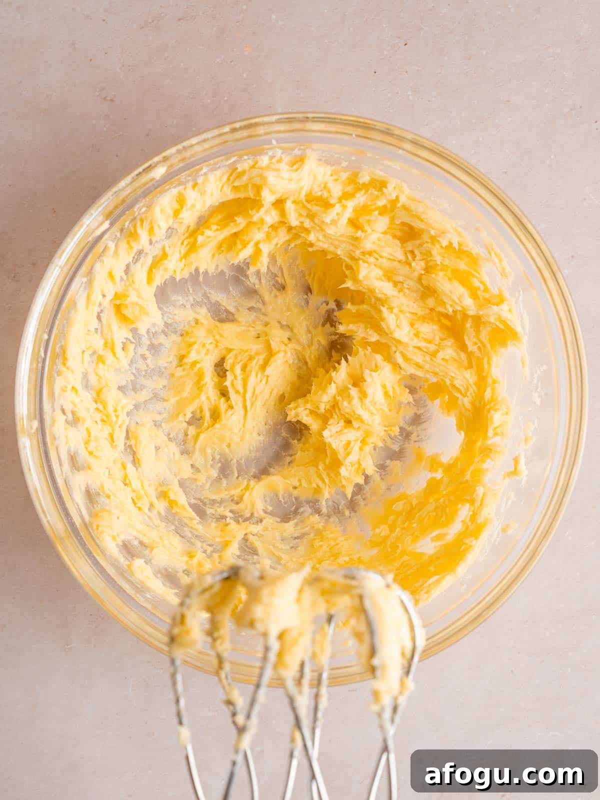 Unsalted butter, granulated sugar, powdered sugar, vanilla extract, and almond extract mixed together in a bowl.