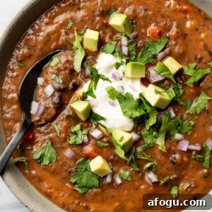 a bowl of black bean soup with a spoon
