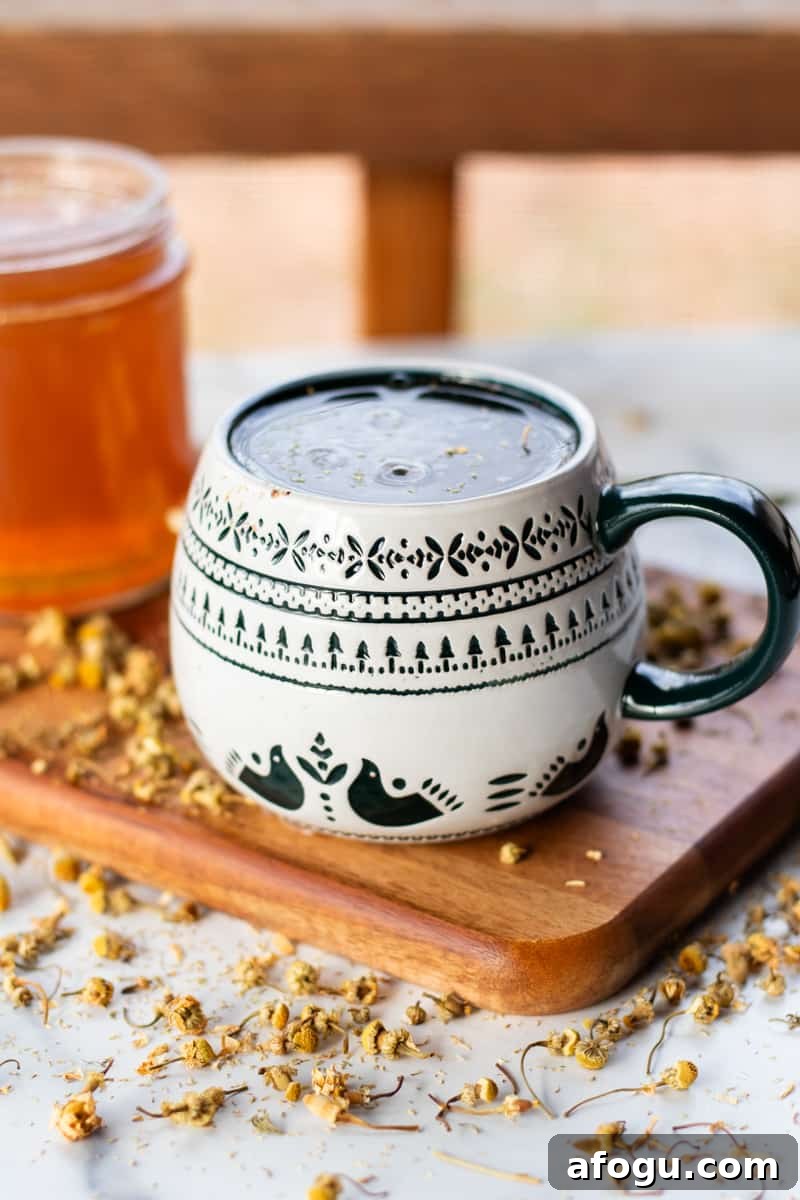 A hand soak made from chamomile tea brewing in a decorated mug.