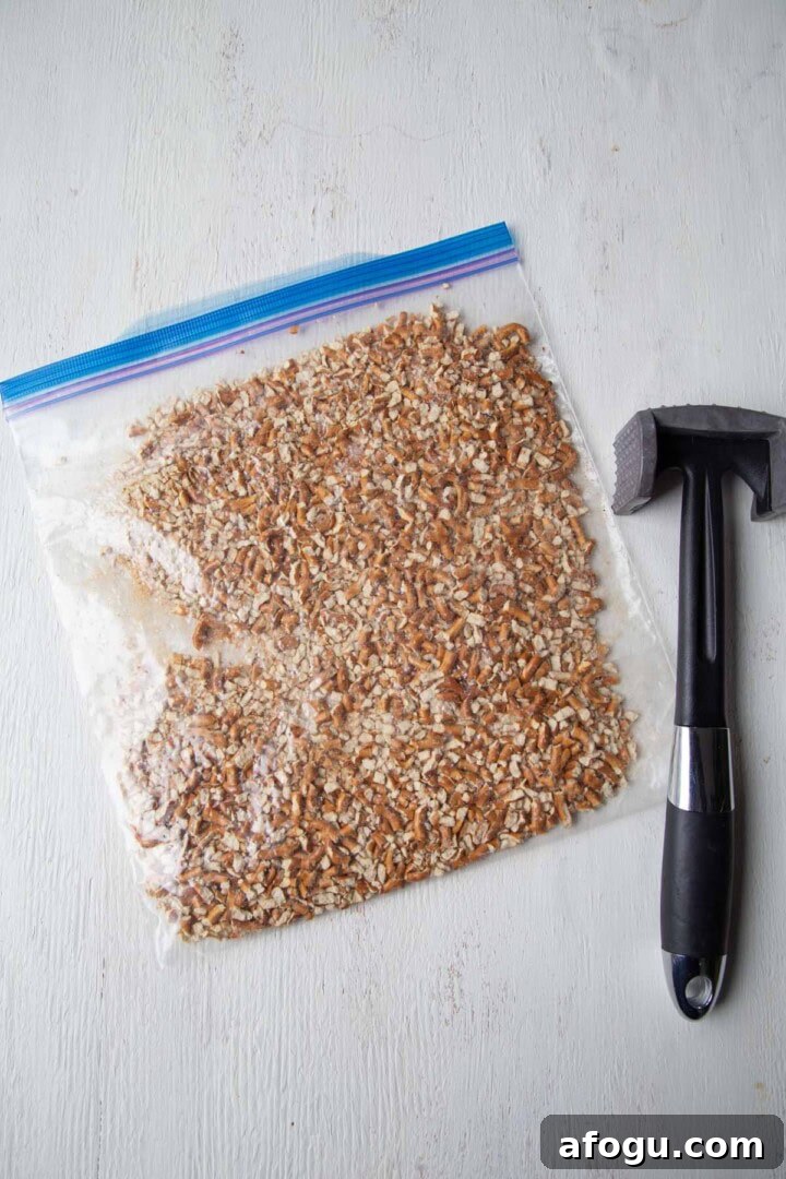 crushed pretzels in a zip top bag with a meat mallet.