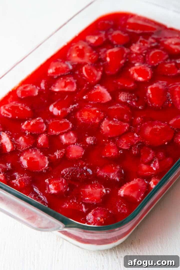 strawberry gelatin on top of a layered dessert.