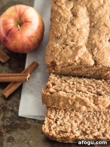 Sliced apple bread with apple and cinnamon sticks.