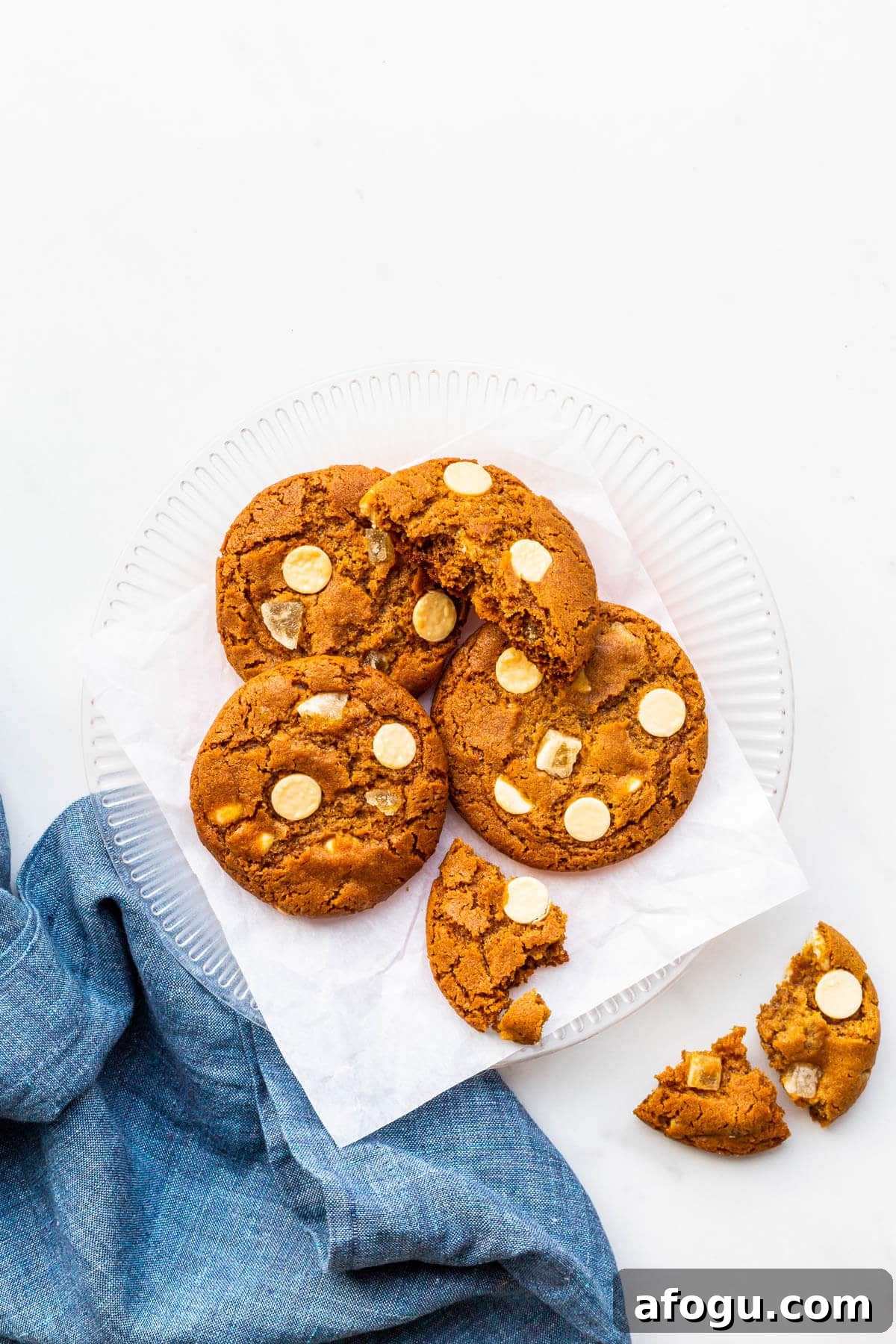 A plate of ginger cookies with white chocolate chips.