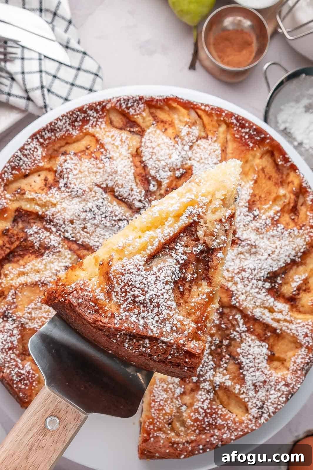 Moist Pear Cake Recipe — 20-Minute Prep, Simple Steps 2 A serving spoon holding a thick slice of moist pear cake, showing the tender vanilla crumb and chunks of baked pear throughout.