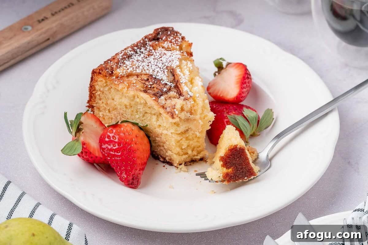 Moist Pear Cake Recipe — 20-Minute Prep, Simple Steps 13 A single slice of easy pear cake on a white plate with a bite taken out, revealing the soft internal texture of the cake.