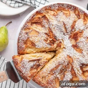 Moist Pear Cake Recipe — 20-Minute Prep, Simple Steps 14 A knife cutting a fresh slice out of a whole round pear cake, showcasing the golden-brown caramelized cinnamon sugar crust.