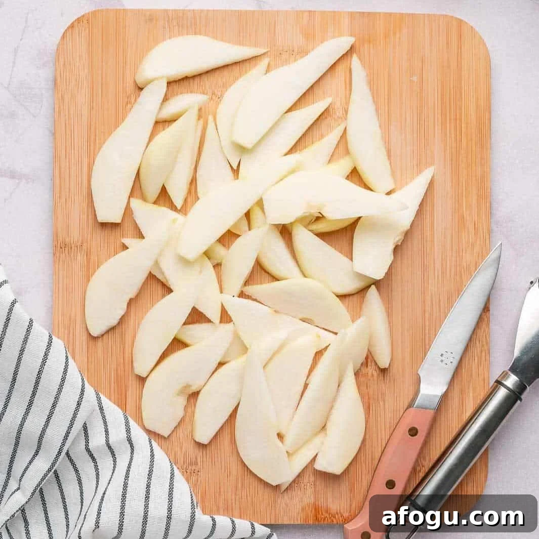 Moist Pear Cake Recipe — 20-Minute Prep, Simple Steps 4 Freshly peeled and thinly sliced Bartlett pears on a wooden cutting board for a classic moist pear cake recipe.