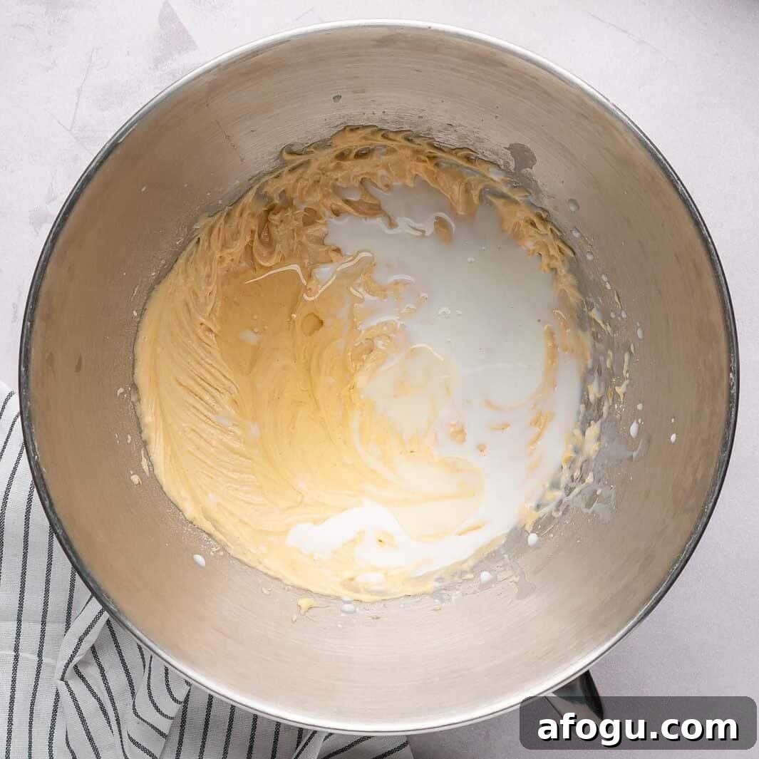 Moist Pear Cake Recipe — 20-Minute Prep, Simple Steps 8 Pouring whole milk into a thick, buttery cake batter and gently folding the mixture together for a smooth, creamy texture.