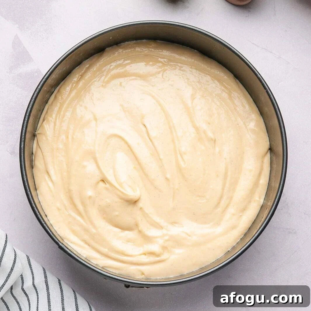 Moist Pear Cake Recipe — 20-Minute Prep, Simple Steps 9 Pouring the smooth, vanilla-flecked cake batter into a pre-greased springform pan to ensure a perfect, non-stick bake for a classic pear cake.